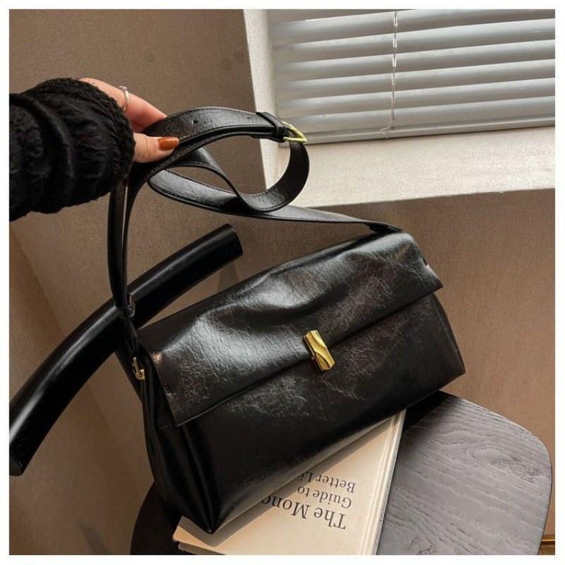Schwarze Baguette-Schultertasche aus weichem Leder mit Überschlag und Goldverschluss
